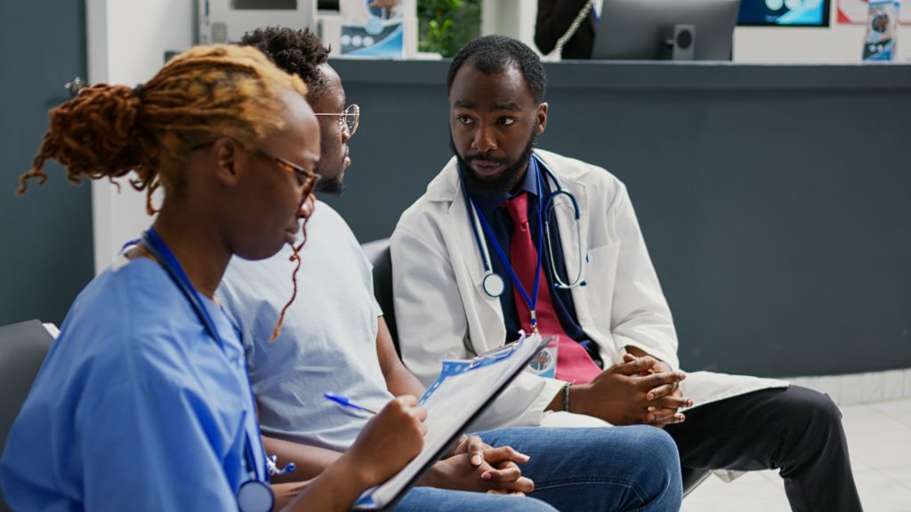 Team of doctors consulting with man in clinic